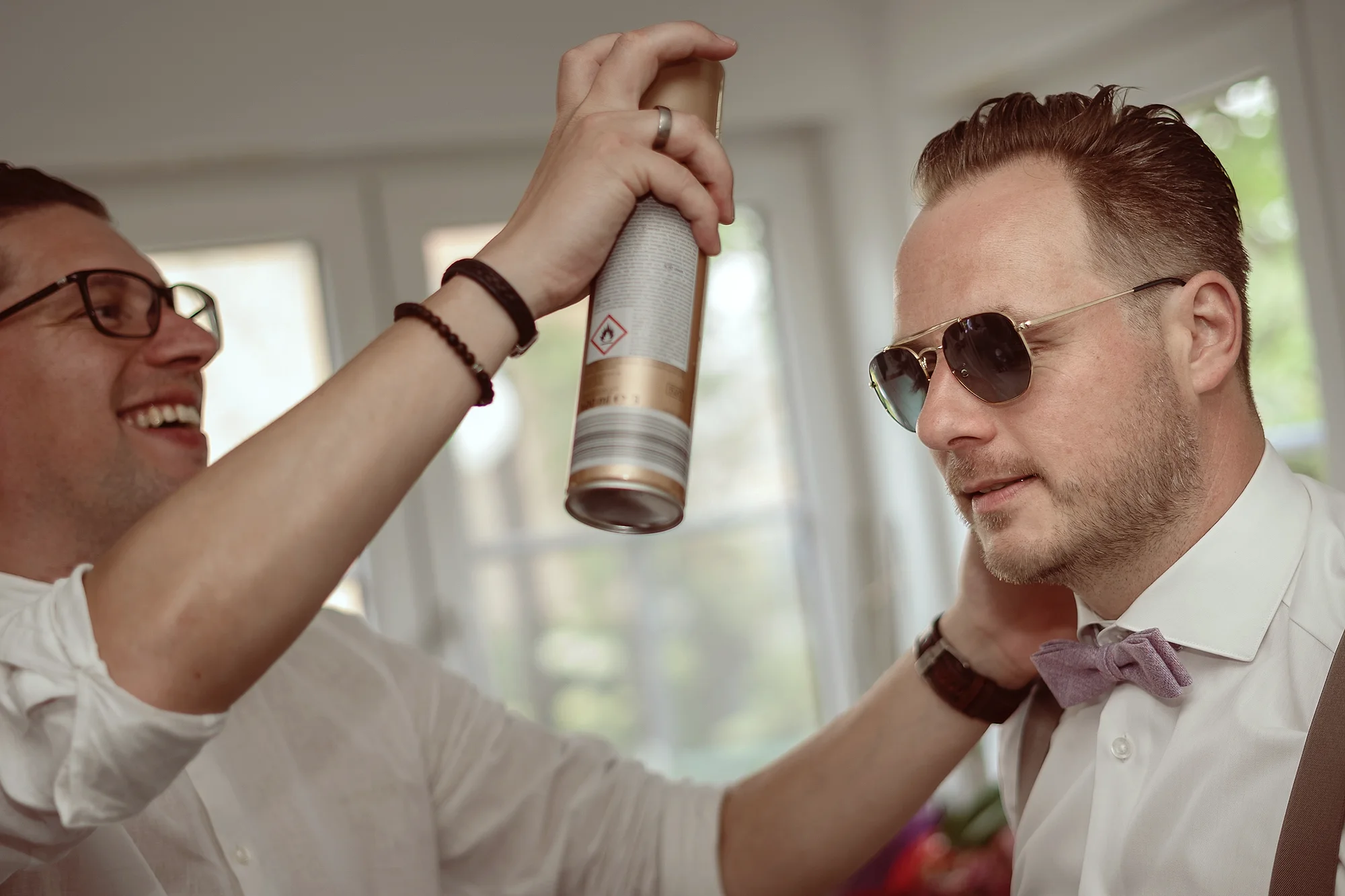 Bruidegom met zonnebril krijgt haarspray