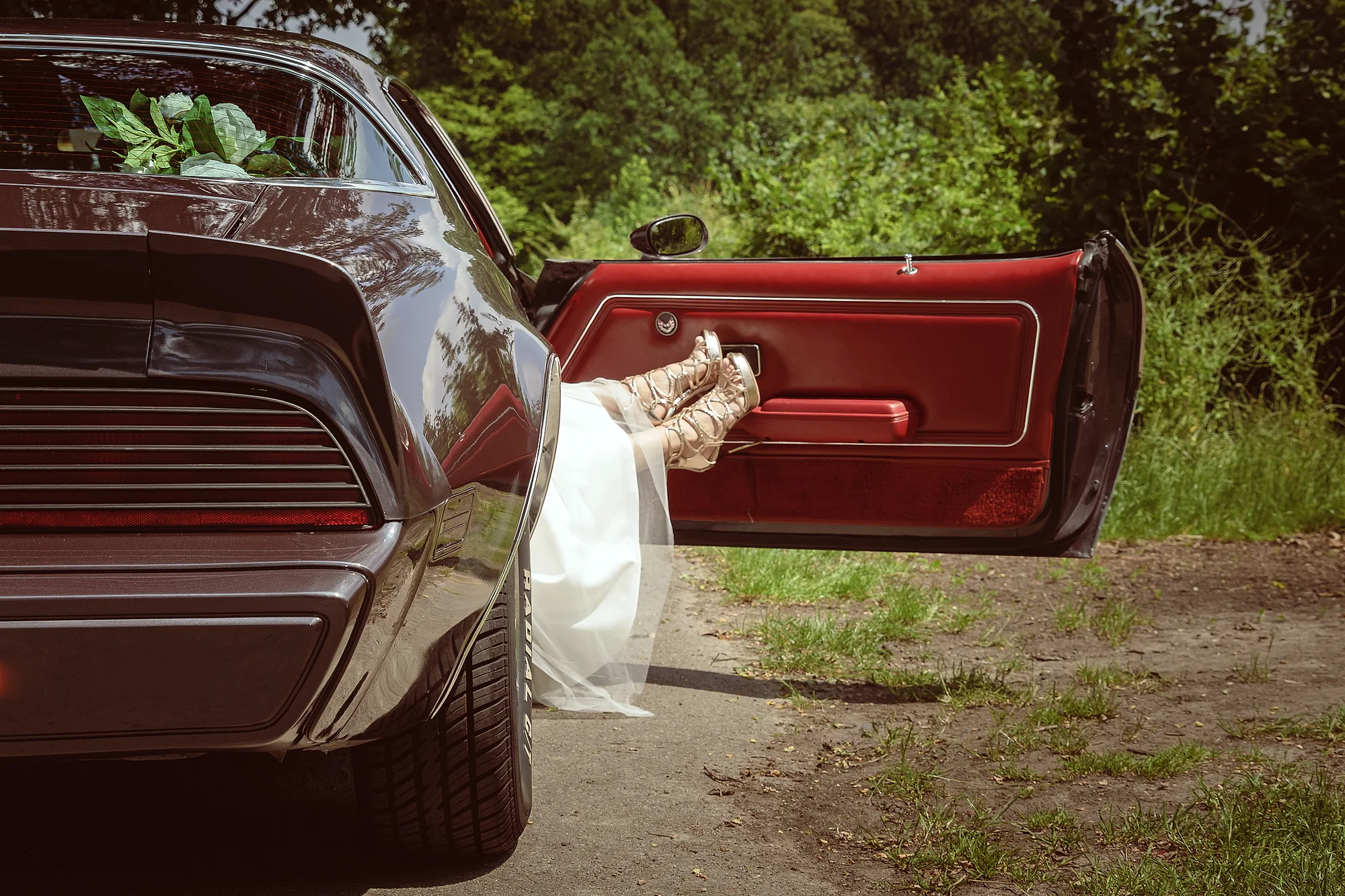 Hakken stappen uit een vintage muscle car met rood interieur