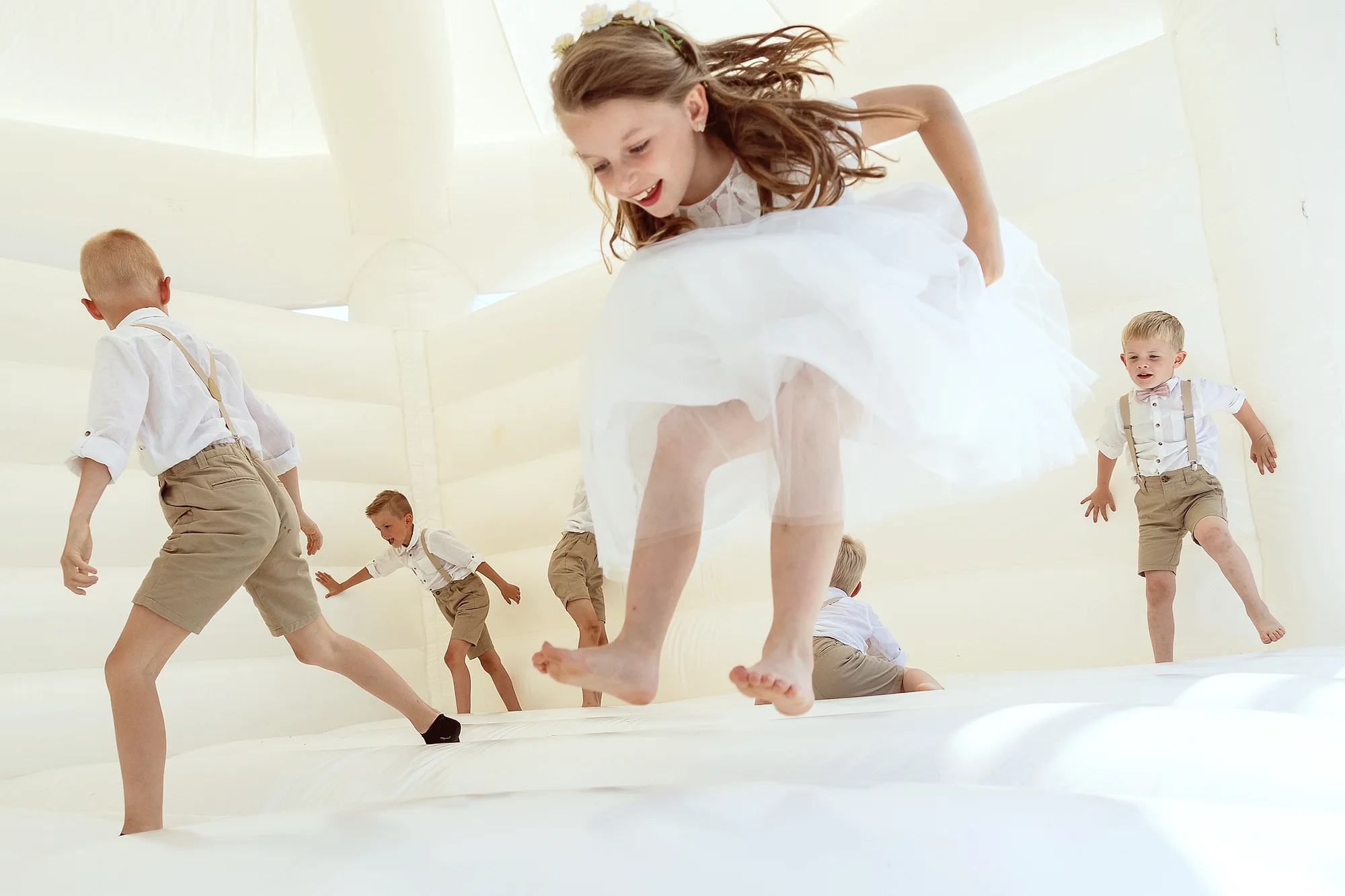 Kids springen in witte springkasteel, motion