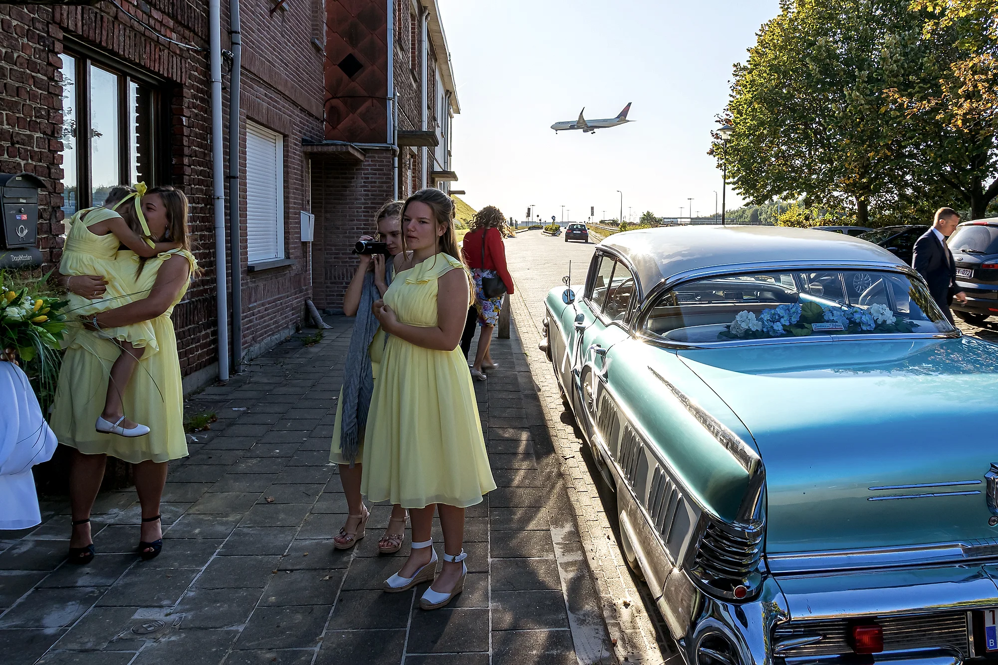 Bruidsmeisjes in geel met vintage cabriolet, vliegtuig boven